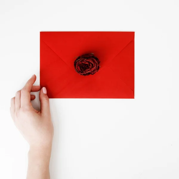Minimalist fashion and beauty photo. A love letter in a red envelope with a rose. Female hands lay a love letter. The concept of St. Valentine's Day. Romantic photography. 14 february — Stock Photo, Image