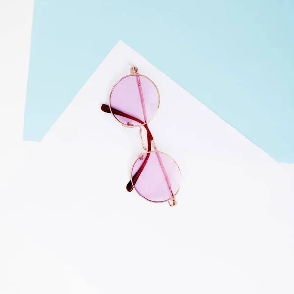 最小限のスタイル。シンプルなファッション写真。ファッション夏は来る概念です。パステル背景、上面にピンクのメガネ。カラフルな紙を背景にトレンディなミニマル スタイル — ストック写真