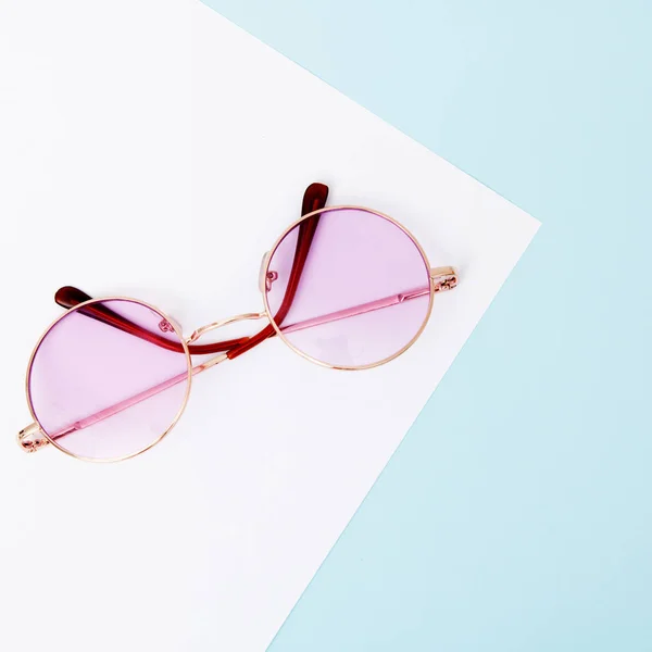 Estilo mínimo. Fotografía minimalista de moda. El verano de la moda viene concepto. Gafas rosadas sobre fondo pastel, vista superior. Estilo minimalista de moda con fondo de papel colorido — Foto de Stock