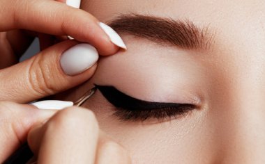 Göz makyajı makyöz geçerlidir. Güzel göz mükemmel bir şekil kaşları ile makro yakın çekim. Güzel kadın göz aşırı uzun kirpik ve siyah liner ile. Mükemmel bir şekil kaşları. Moda ve güzellik