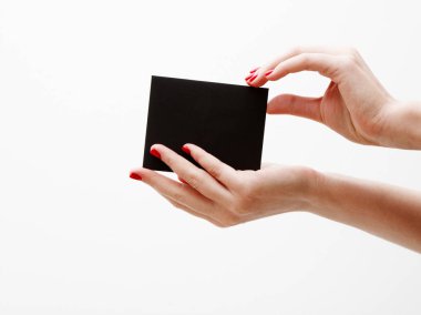 Düz yatıyordu, en iyi görünüm. Güzellik ve moda kavramı. Güzel eller kırmızı manikür ile. En az tarzı. Minimalist fotoğraf. Beyaz arka plan üzerinde indirim kartı tutan kız el ile kompozisyon