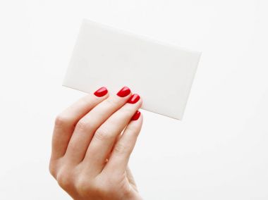 Düz yatıyordu, en iyi görünüm. Güzellik ve moda kavramı. Güzel eller kırmızı manikür ile. En az tarzı. Minimalist fotoğraf. Beyaz arka plan üzerinde kart tutan kız el ile soluk kompozisyon