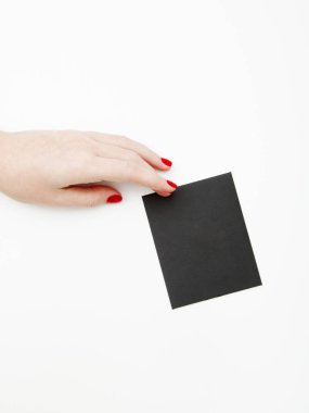 Düz yatıyordu, en iyi görünüm. Güzellik ve moda kavramı. Güzel eller kırmızı manikür ile. En az tarzı. Minimalist fotoğraf. Beyaz arka plan üzerinde kart tutan kız el ile soluk kompozisyon