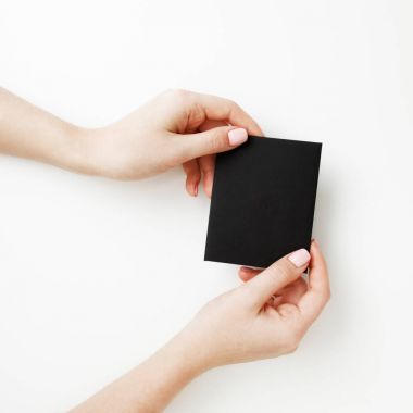 Düz yatıyordu, en iyi görünüm. Güzellik ve moda kavramı. Güzel eller kırmızı manikür ile. En az tarzı. Minimalist fotoğraf. Beyaz arka plan üzerinde indirim kartı tutan kız el ile kompozisyon
