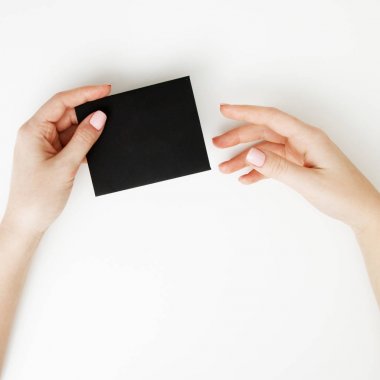 Düz yatıyordu, en iyi görünüm. Güzellik ve moda kavramı. Güzel eller kırmızı manikür ile. En az tarzı. Minimalist fotoğraf. Beyaz arka plan üzerinde indirim kartı tutan kız el ile kompozisyon