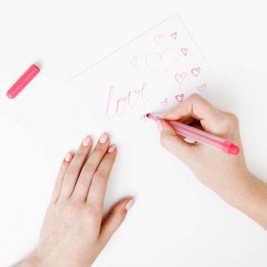 Düz yatıyordu. Üstten Görünüm. Kızın Saint Sevgililer günü aşk mektubu yazma el. El yapımı kart kırmızı kalp şeklinde rakam ile. Kadın kart 14 Şubat tatil kutlaması için aşk yazmak