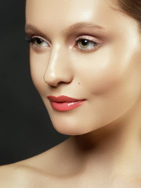 Çıplak makyaj. Güzellik kadını yüz portre. Güzel spa modeli mükemmel temiz cilt kızla. Kadın kameraya bakıyor ve gülümsüyor. Gençlik ve cilt bakım kavramı. Bir koyu gri arka plan üzerinde izole