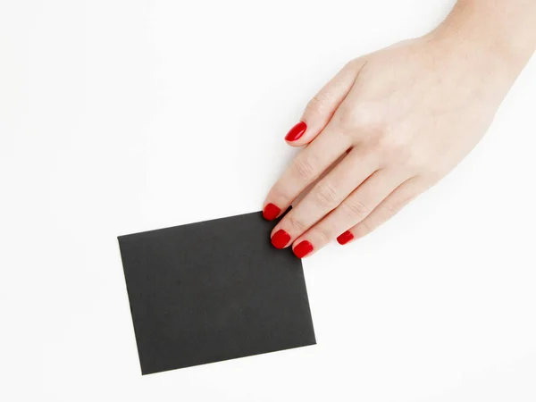 Deitado plano, vista superior. Conceito de beleza e moda. Belas mãos femininas com manicure vermelho. Estilo mínimo. Fotografia minimalista. Composição pálida com cartão de mão da menina no fundo branco — Fotografia de Stock