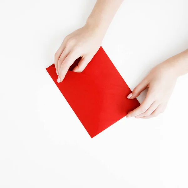 Flat lay. Top view. A minimalistic style of fashion and beauty photography. Hands holding craft paper gift envelope with as a present for Christmas, new year, valentine day or anniversary — Stock Photo, Image