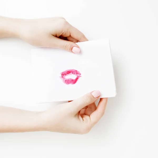 Leżał z płaskim. Widok z góry. Dłoń dziewczyny pisać list miłosny na Saint Walentynki. Pocztówka z czerwone usta w kształcie rysunek. Kobieta rysować pocałunek na pocztówkę do 14 lutego świąteczny — Zdjęcie stockowe