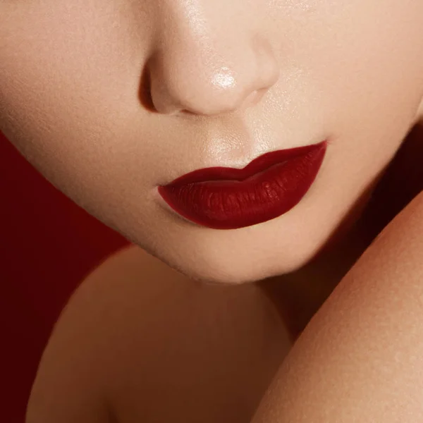 Extrema close-up no modelo aplicando batom vermelho escuro. Maquiagem. Maquiagem retro de moda profissional. batom vermelho escuro. Lábios de vinho — Fotografia de Stock