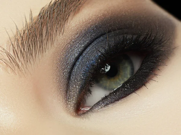 Close up of blue woman eye with beautiful brown with red and orange shades smokey eyes makeup. Modern fashion make up. — Stock Photo, Image