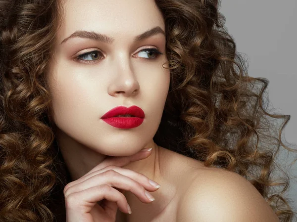 Brünettes Mädchen mit langen und glänzenden welligen Haaren. schönes Modell mit lockiger Frisur. rote Lippen — Stockfoto
