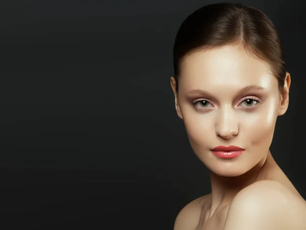 Nude Make-up. Schönheit Frau Gesicht Porträt. schöne Wellness-Modell Mädchen mit perfekt sauberer Haut. Frau blickt in die Kamera und lächelt. Jugend- und Hautpflegekonzept. isoliert auf dunkelgrauem Hintergrund — Stockfoto