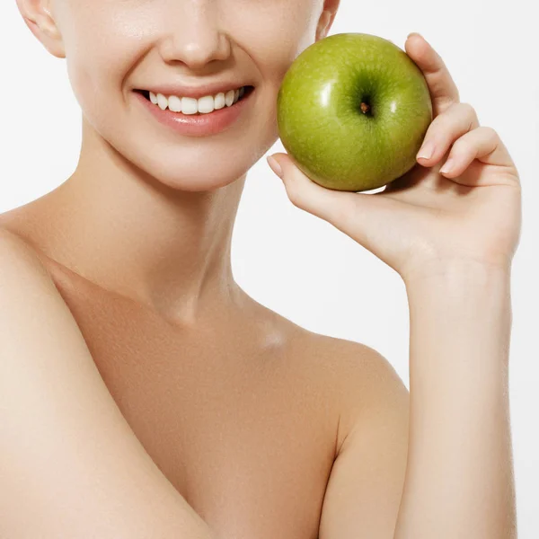 Beauty concept. White teeth. Dental care. Portrait of attractive caucasian smiling woman isolated on white studio shot eating green apple — Stock Photo, Image