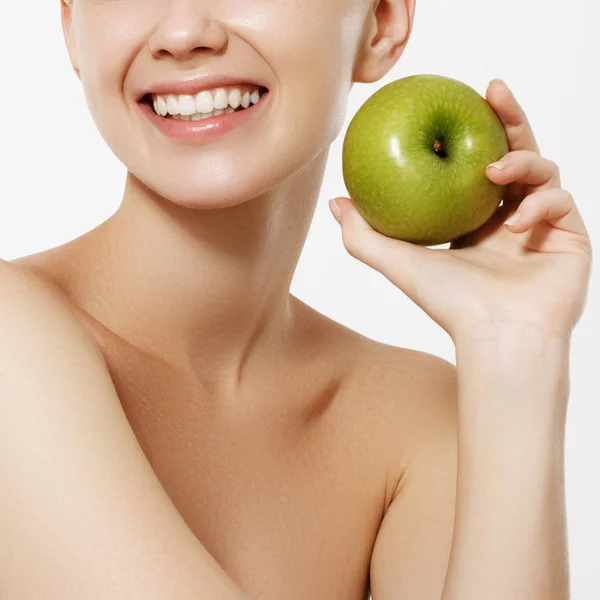 Beauty concept. White teeth. Dental care. Portrait of attractive caucasian smiling woman isolated on white studio shot eating green apple — Stock Photo, Image