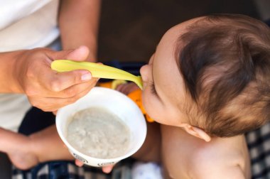 Bir çocuk bir bebek maması yiyor