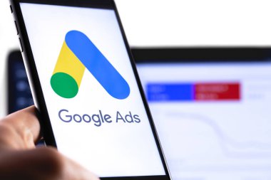 Ekrandaki akıllı telefon ve defter arkaplanındaki Google ilanları simgesi. Reklamlar, temelde Google 'dan gelen bir arama reklamları servisidir. Moskova, Rusya - 25 Ağustos 2019