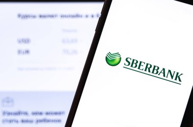Akıllı telefon ve defterde Sberbank logosu var. Sberbank, Rusya, Orta ve Doğu Avrupa 'nın en büyük uluslararası ve evrensel bankasıdır. Moskova, Rusya - 25 Eylül 2019