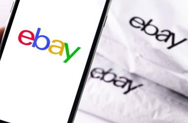 Ekran akıllı telefonunda ebay logosu, Ebay plastik torba arka planda yakın plan. eBay en büyük online açık artırma ve alışveriş sitelerinden biridir. Moskova, Rusya - 23 Mart 2019