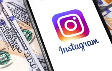 Akıllı telefondaki Instagram sembolü dolarlarla, yakın plan para. Sosyal medya. Instagram akıllı telefonlar için fotoğraf paylaşım uygulamasıdır. Moskova, Rusya - 25 Eylül 2019