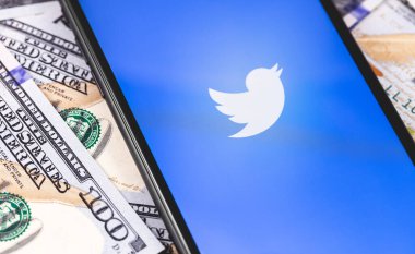 Twitter logosu ekranda akıllı telefon ve para, dolar. Twitter, mikroblog ve ağ iletişimi için bir sosyal medya hizmetidir. Moskova, Rusya - 1 Mart 2019