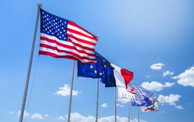 Amerika Birleşik Devletleri, Avrupa ve Fransa 'nın bayrakları mavi gökyüzünde rüzgarda dalgalanıyor. 