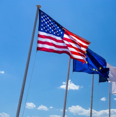 Amerika Birleşik Devletleri 'nin bayrakları, Avrupa mavi gökyüzünde rüzgarda dalgalanıyor. 