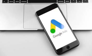 Ekran iPhone üzerindeki Google Ads (AdWords) logosu, dizüstü bilgisayar kapatma arkaplanı. Reklamlar, temelde Google 'dan gelen bir arama reklamları servisidir. Moskova, Rusya - 19 Aralık 2019