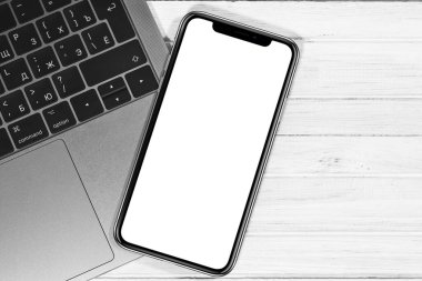 iPhone maketi ve Macbook beyaz masaya yakın çekim. Grafik görüntüleme için boş ekran cep telefonu. Moskova, Rusya - 23 Aralık 2019