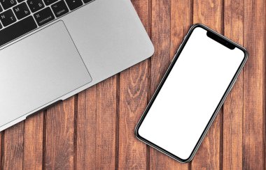 iPhone 'un Macbook' la ahşap masada yakın plan modeli. Grafik görüntüleme için boş ekran cep telefonu. Moskova, Rusya - 26 Aralık 2019