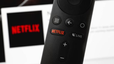 Ekran defteri arkaplanındaki uzaktan kumandadaki Netflix kırmızı düğmesi. Netflix, televizyon bölümleri ve filmler için uluslararası bir abonelik servisidir. Moskova, Rusya - 11 Nisan 2019