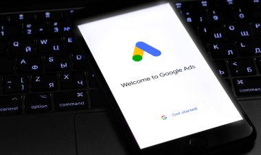 Ekran iPhone 'unda Google Ads (AdWords) logosu, karanlıkta Macbook klavyesi. Reklamlar, temelde Google 'dan gelen bir arama reklamları servisidir. Moskova, Rusya - 1 Nisan 2020