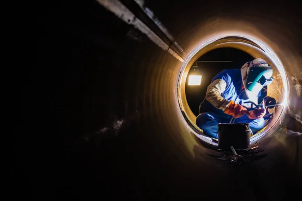 Workers welding work at night in the pipeline.