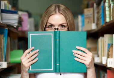 arkasından kitaplar gözlük, üniversite öğrencisi kız bakıyor, öğret