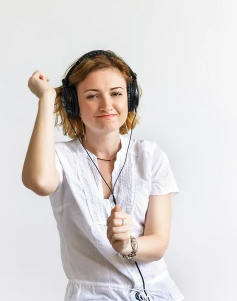 Chica en auriculares escucha música y bailes, en camisa belots , — Foto de Stock