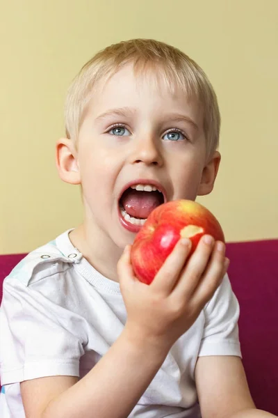 Güzel bir çocuk bir elma yiyor, meyve enjo için bir parça yemek — Stok fotoğraf