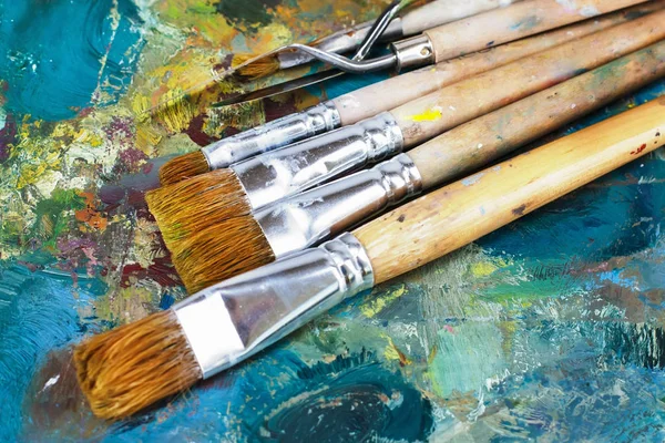 Konstnärens palett med oljefärger och borstar — Stockfoto