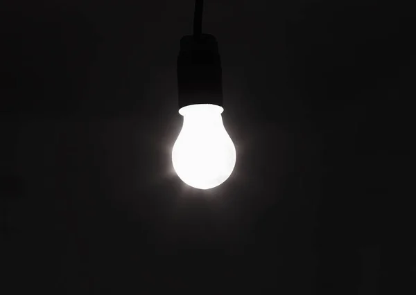 Light bulb shines a bright light, soft focus — Stock Photo, Image