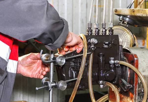 Professional mechanics testing diesel injector in his workshop, — Stock Photo, Image