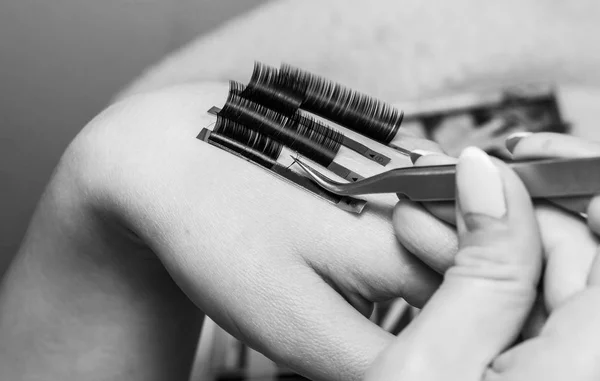 Artificial eyelash extensions, the master's hand, eyelash extens — Stock Photo, Image