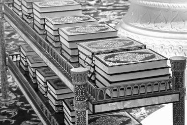 Camide kuran raflarda inci kitap yığınları yatıyor.