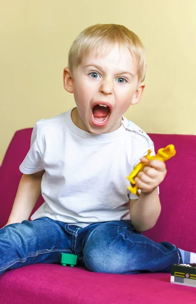 Glücklicher kleiner Junge spielt einen Spielzeug-Dinosaurier, — Stockfoto