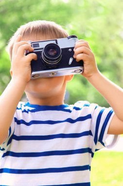 Mutlu neşeli çocuk ile bir fotoğraf makinesi, açık havada fotoğraflandı bebek