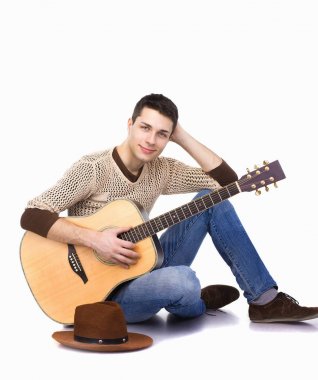 Beyaz arka plan üzerinde oturan gitar ile adam müzisyen 