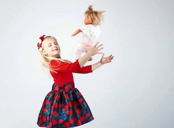 Little happy girl playing a doll, on a white — Stock Photo, Image