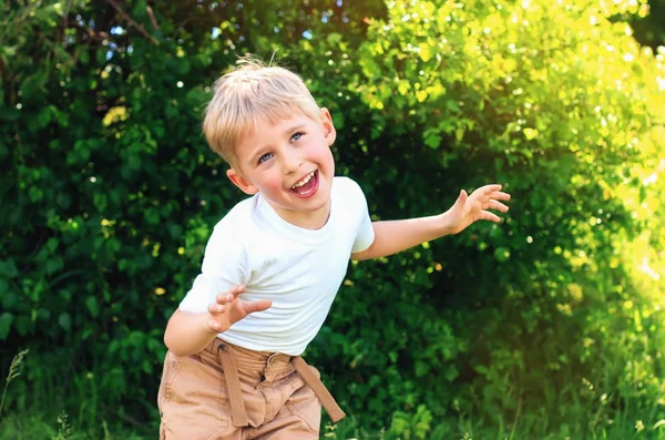 Menino brincando no parque com um rosto sorridente feliz e loiro — Fotografia de Stock