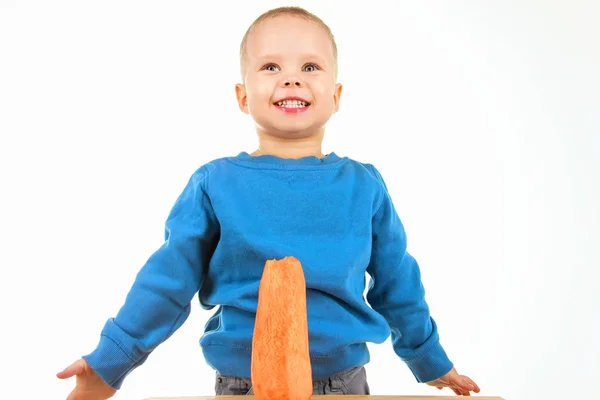 Niño feliz comiendo zanahoria, sobre fondo blanco —  Fotos de Stock