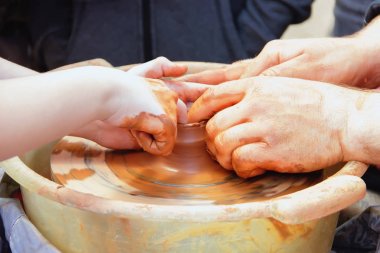 Master potter çocuk bir sürahi bir potte üzerinde yapmayı öğretir.