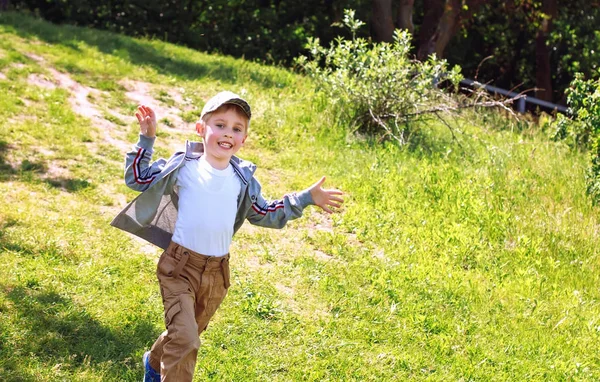 Menino feliz se divertindo correndo na grama , — Fotografia de Stock